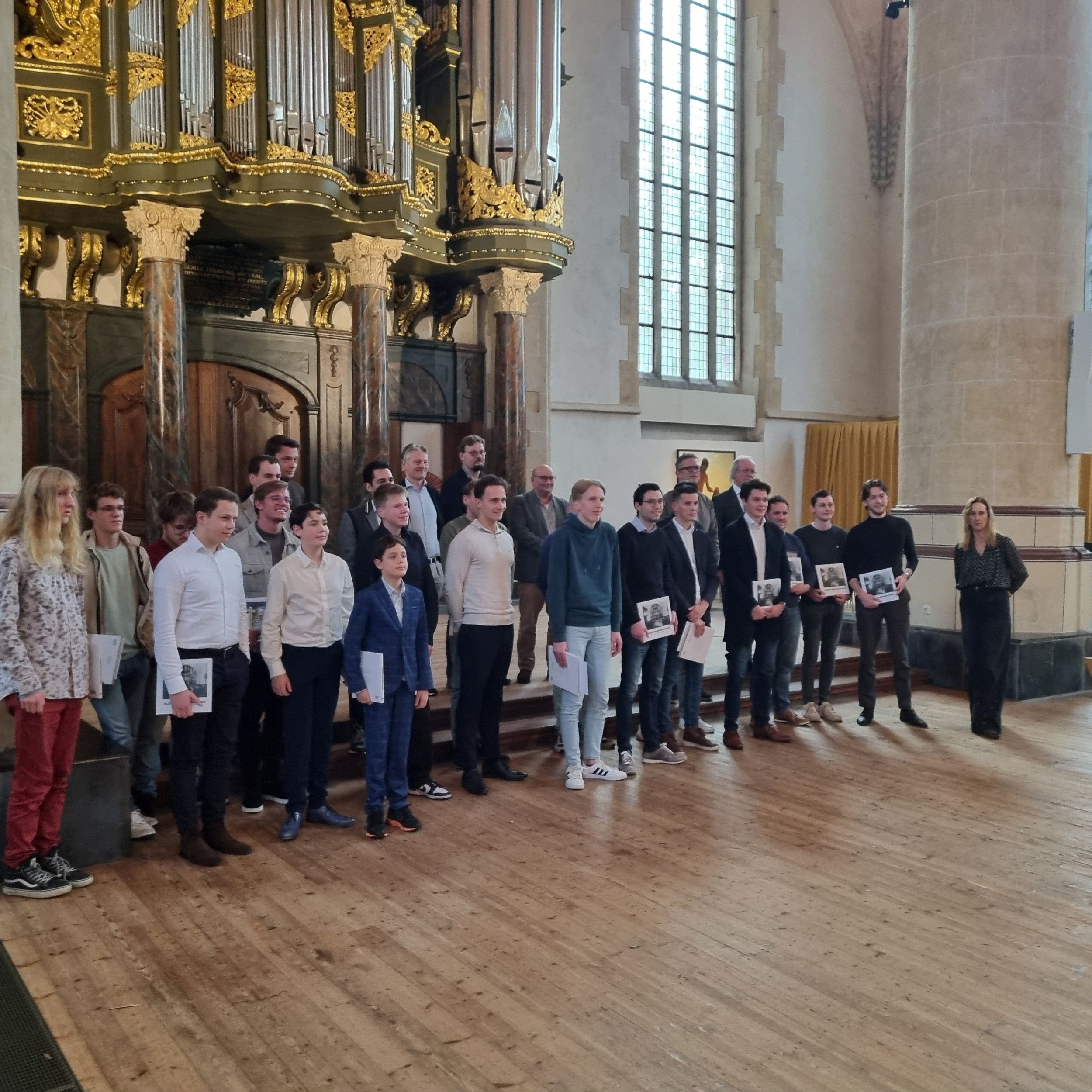 Mensen staat naast elkaar in een lange rij in een grote kerk. 