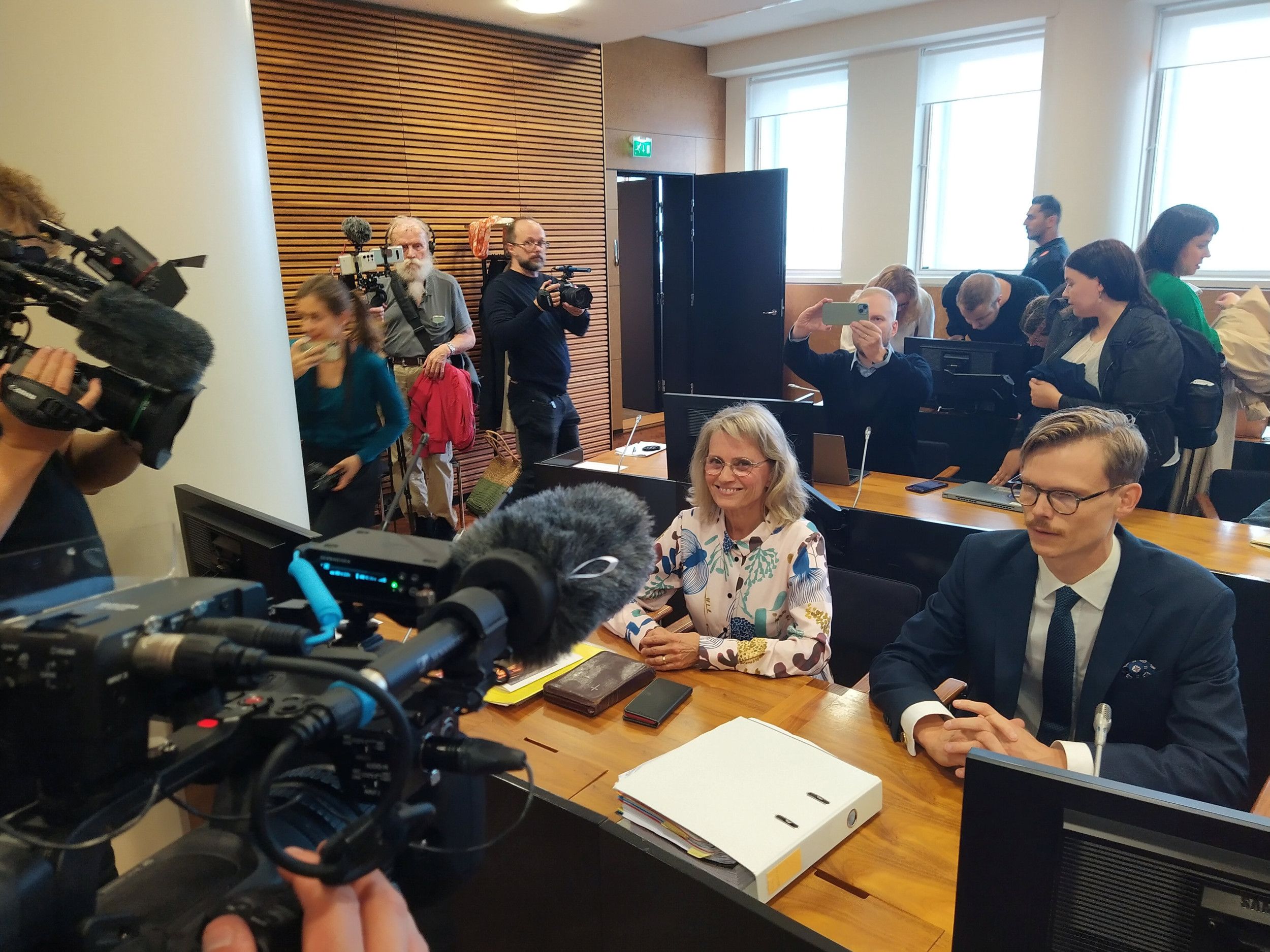 man en vrouw achter tafel in het oog van camera’s