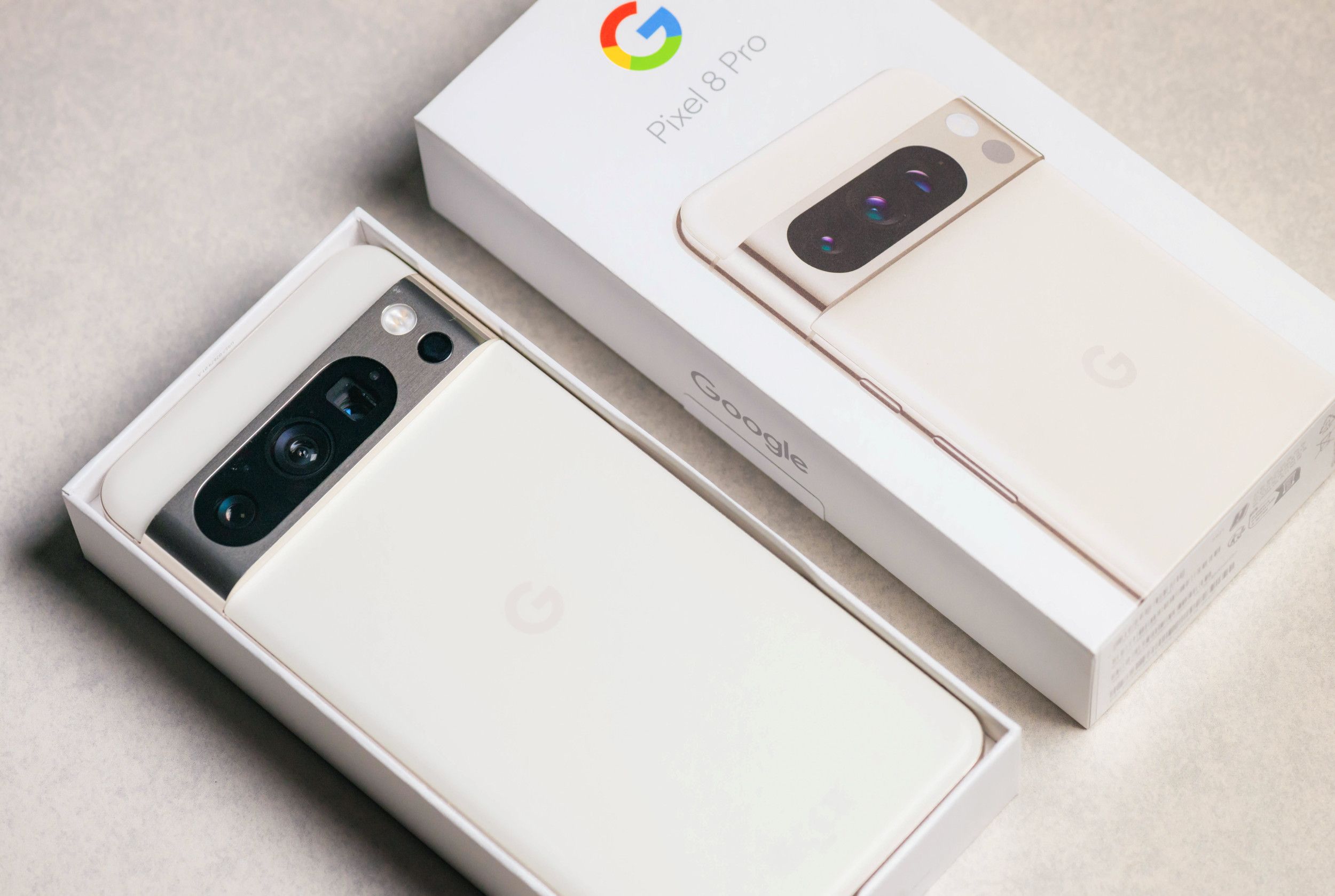 Close-up van een nieuwe Google Pixel 8 Pro-smartphone in porseleinwit, in de meegeleverde verpakking.