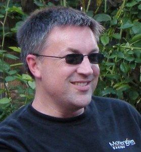 Portret van een man met zonnebril en zwart T-shirt.