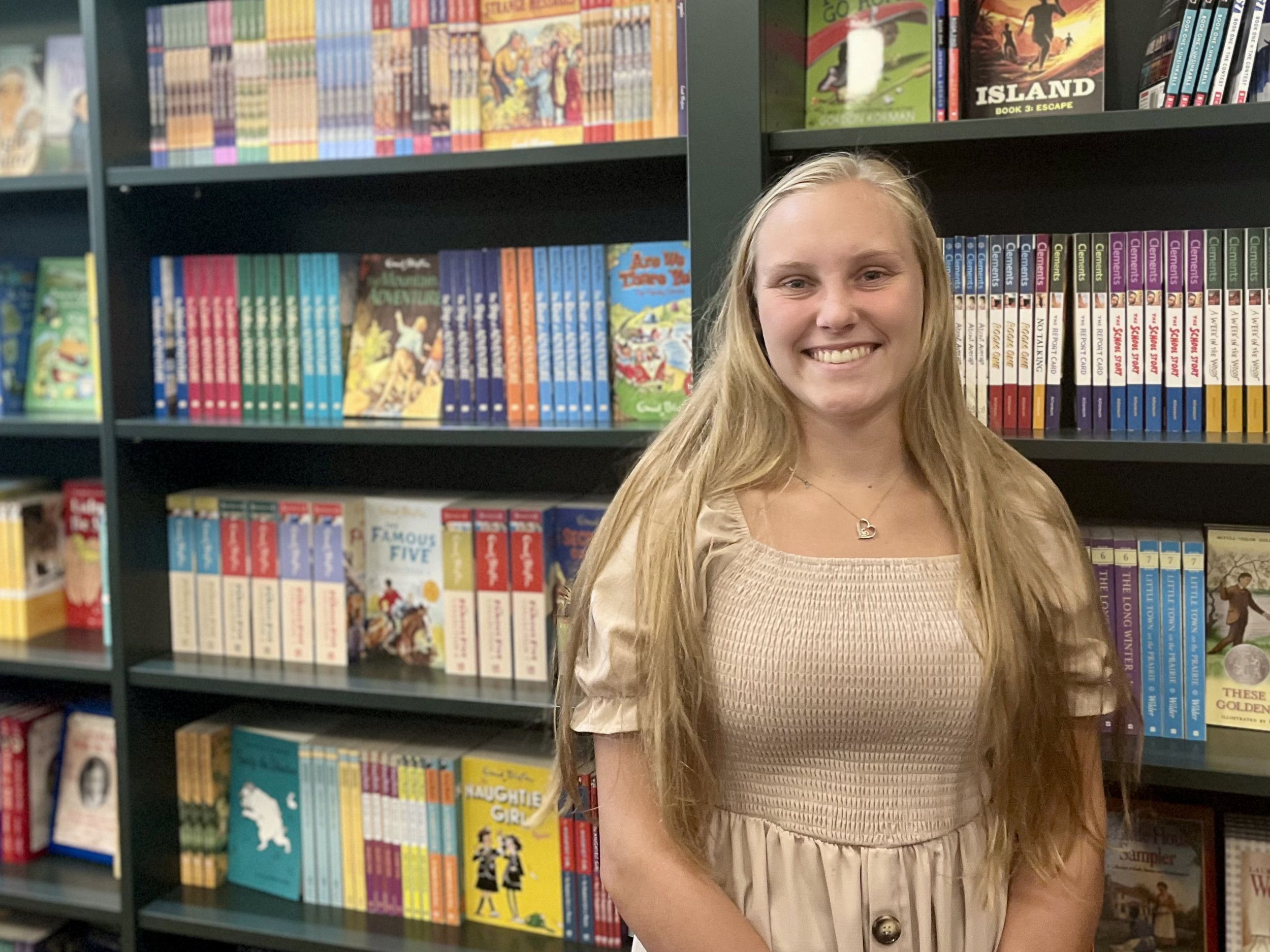 Meisje van 18 voor een kast met nieuwe boeken.