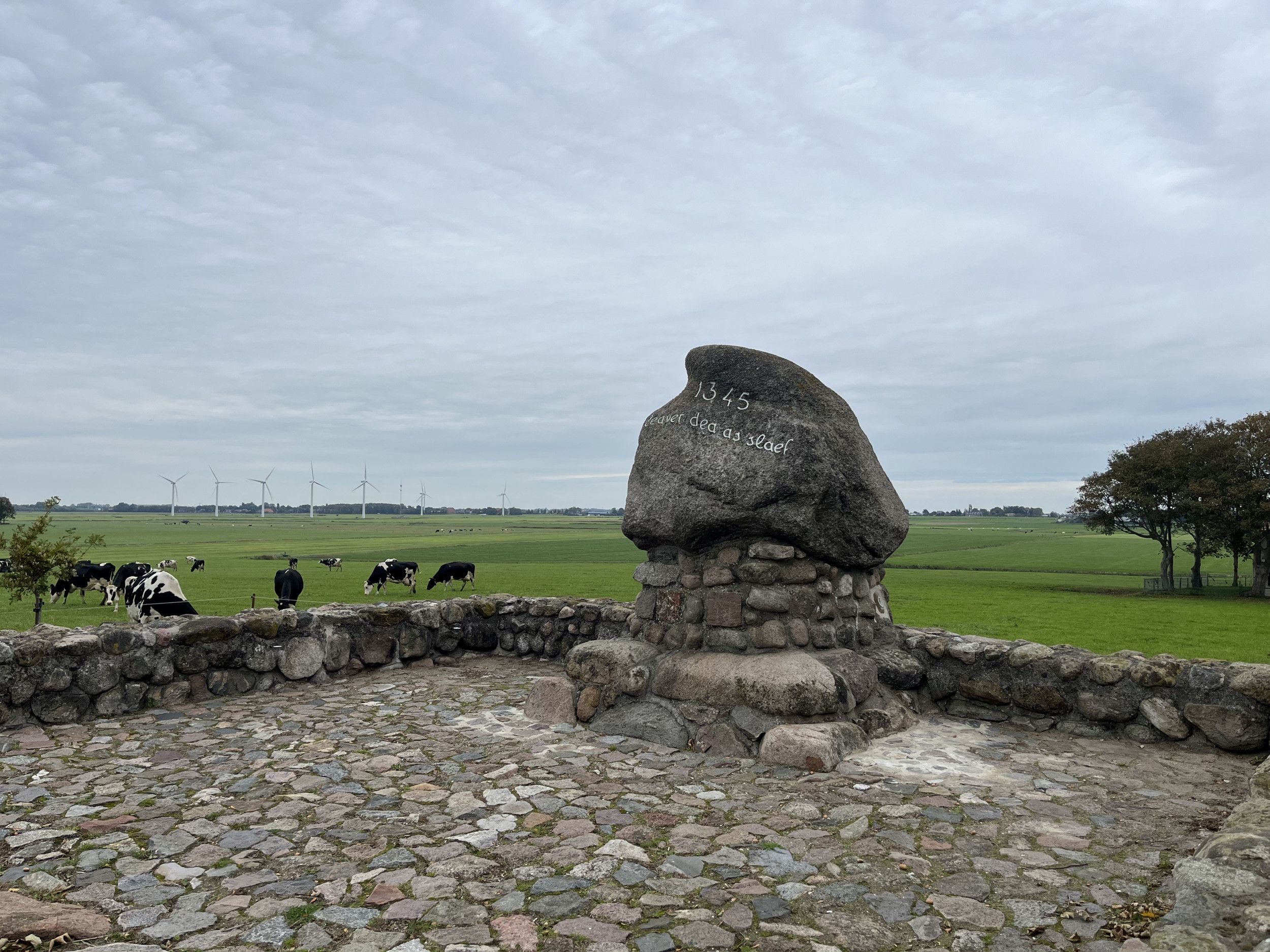 Een grote steen staat op andere stenen gestapeld. Op de steen staat 1345; en in het Fries: ”Liever dood dan slaaf”.