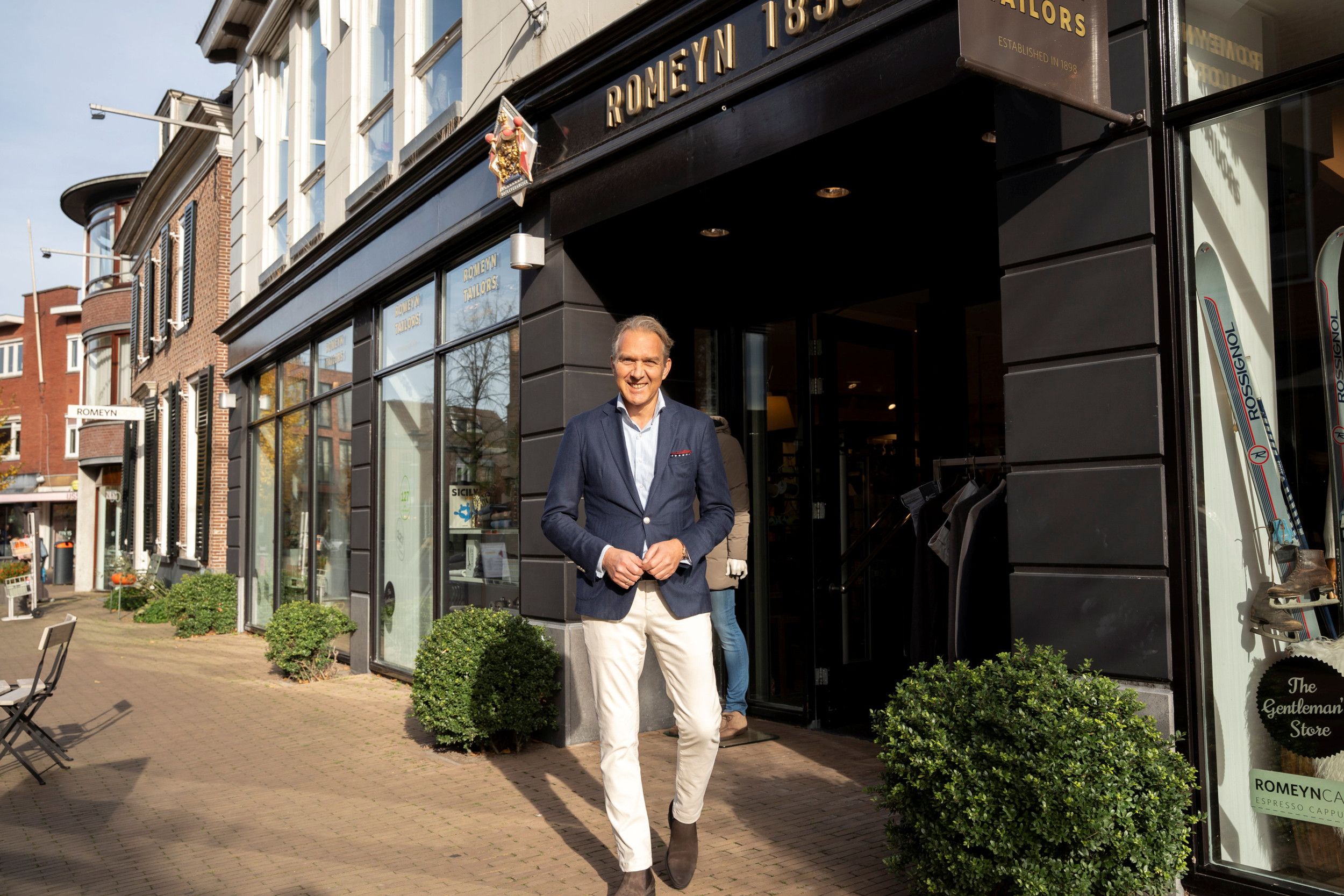 Man voor etalage in winkelstraat