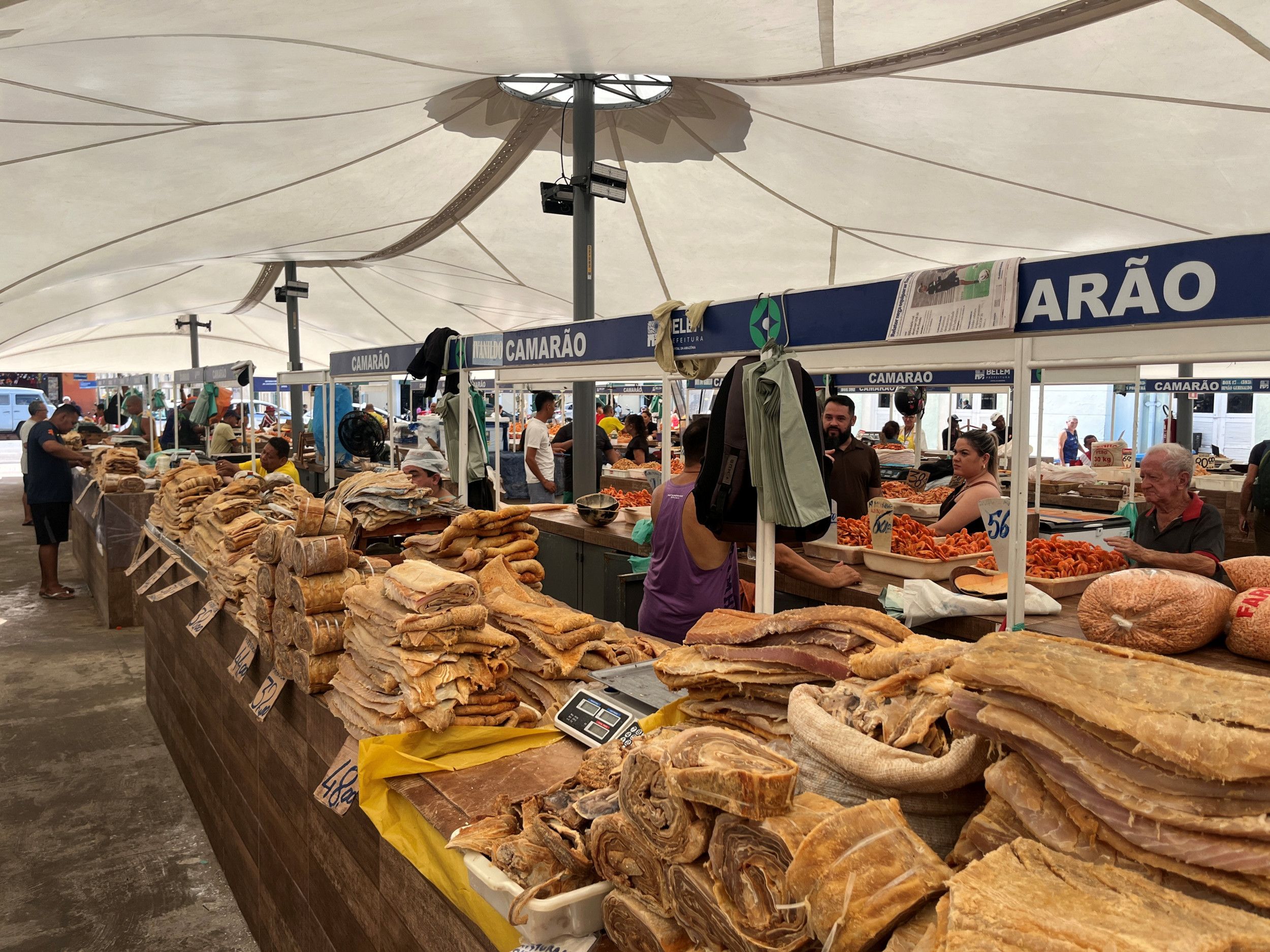 De visafdeling op de markt met grote stapels bruinkleurige vis op de toonbank.