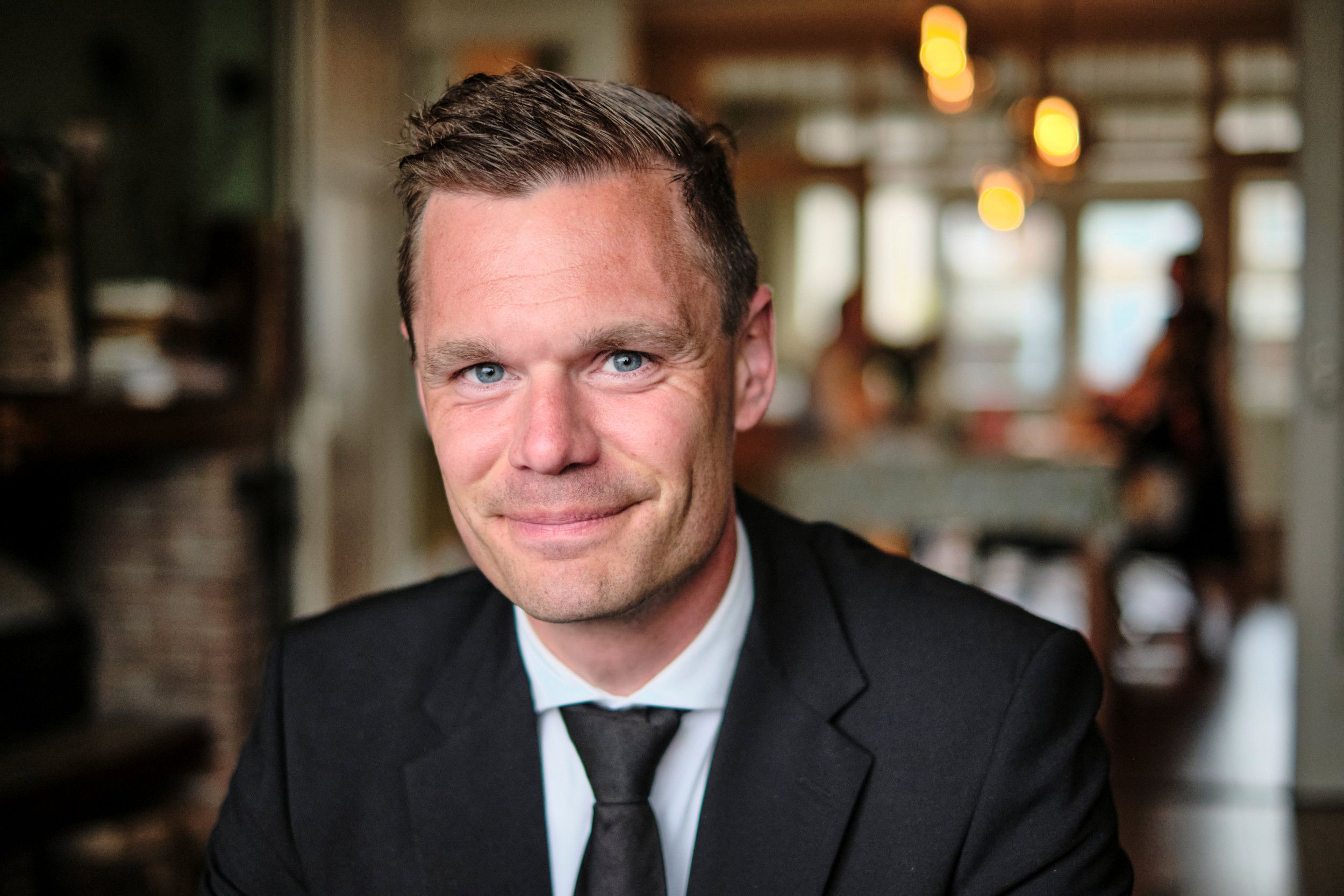 Man in zwart pak met stropdas