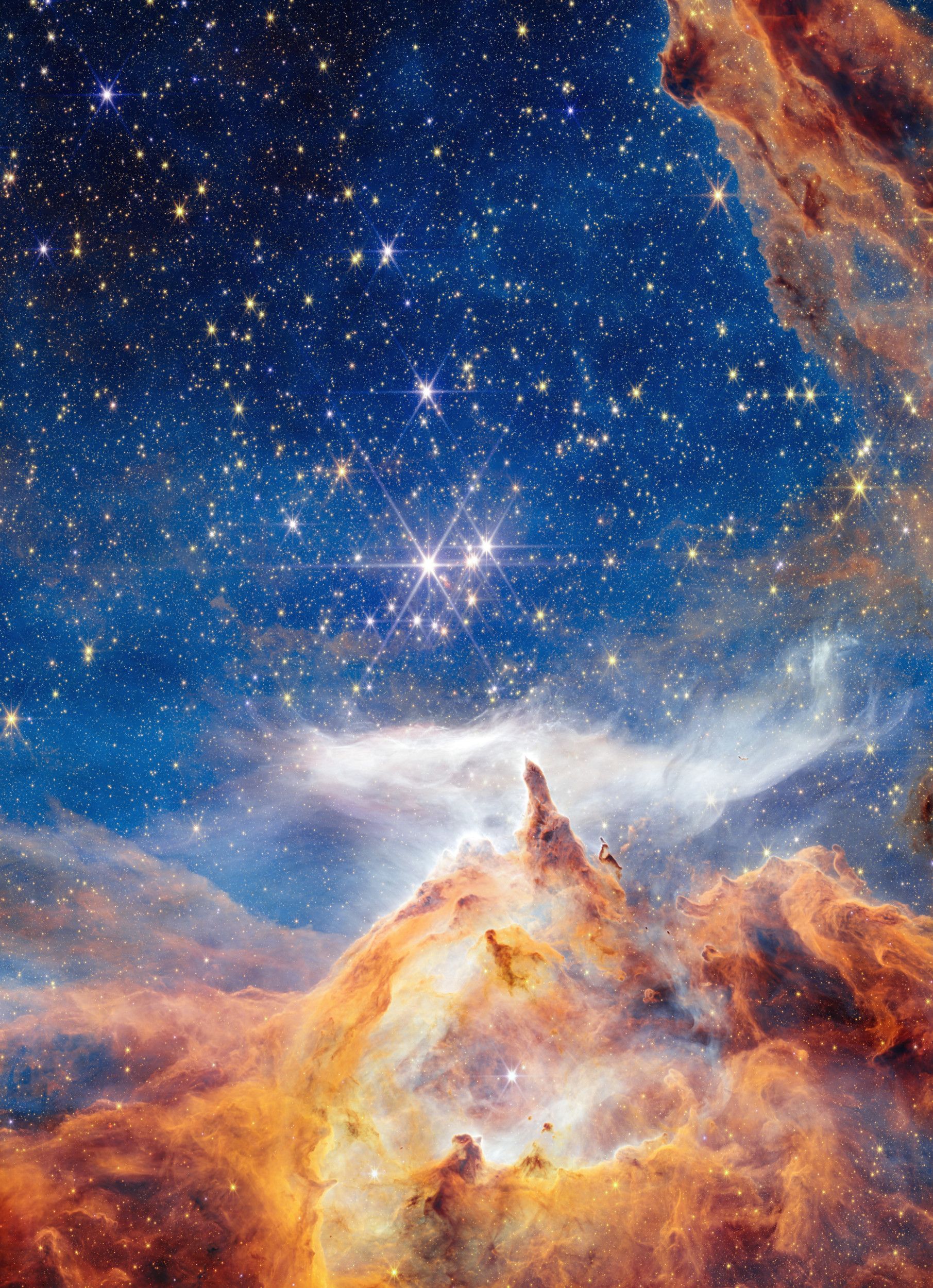 Blauwe achtergrond met flonkerende sterren, gas- en stofwolken en kosmisch gruis.