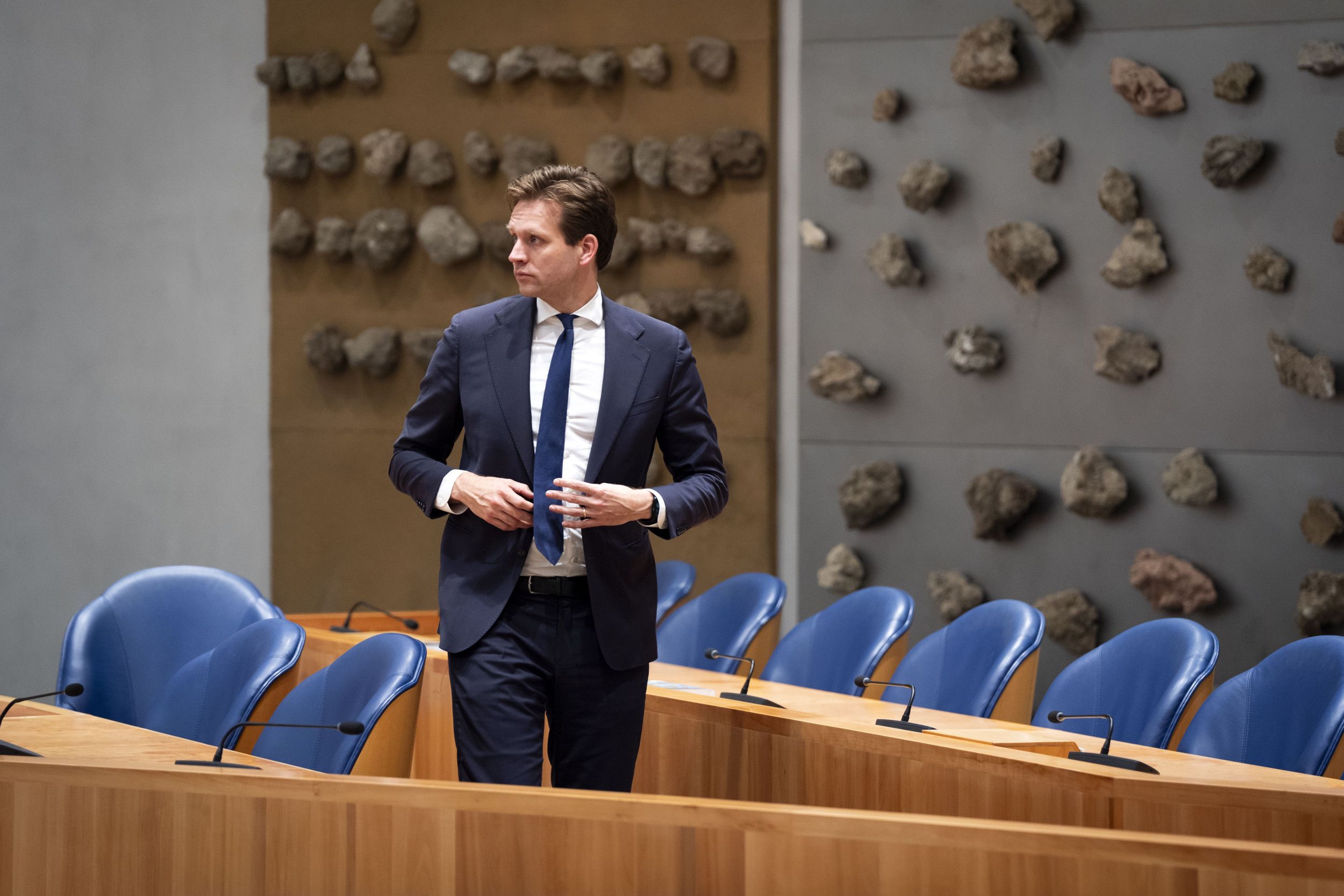 Een man in pak loopt door een leeg vak K. 