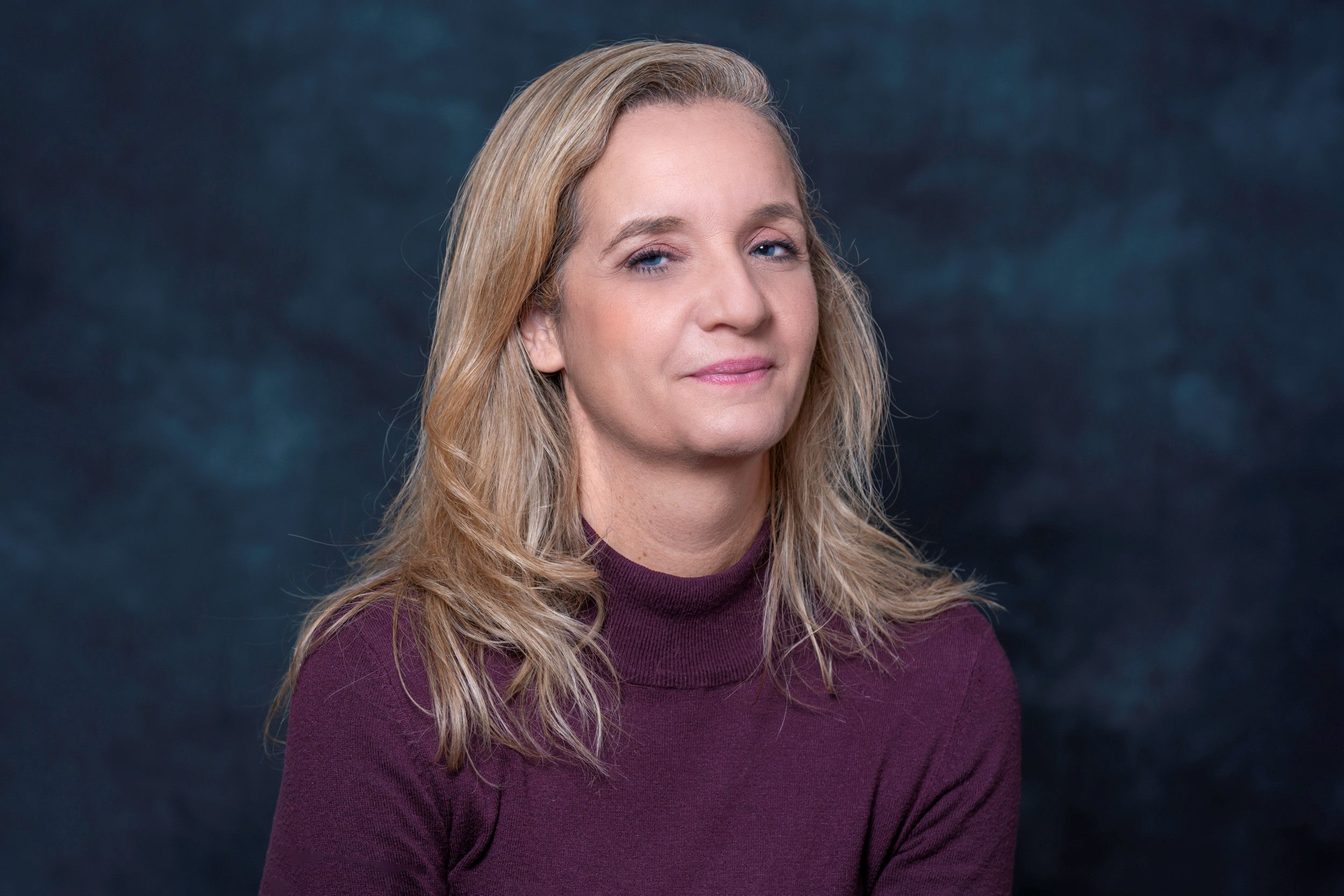 Blonde vrouw met bordeaux trui.