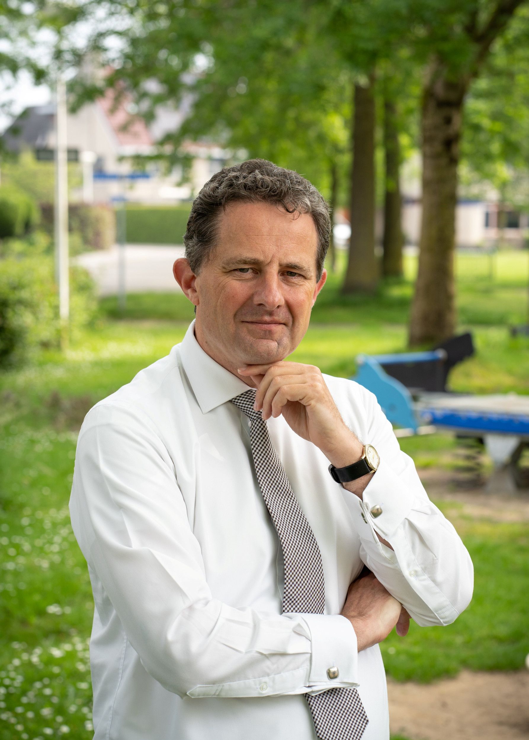 Portret van een man met wit overhemd en zwart-witte stropdas.