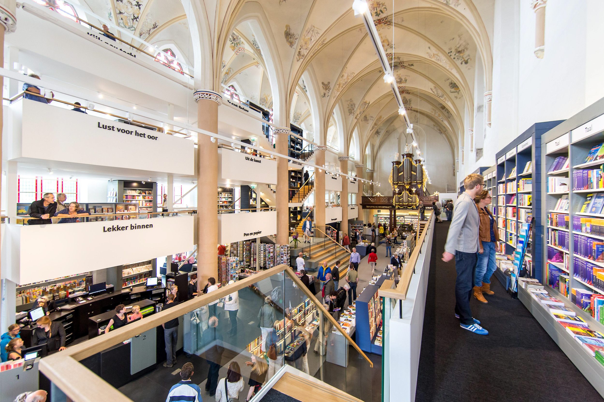 Een voormalig kerkgebouw met boekenkasten en bezoekers.