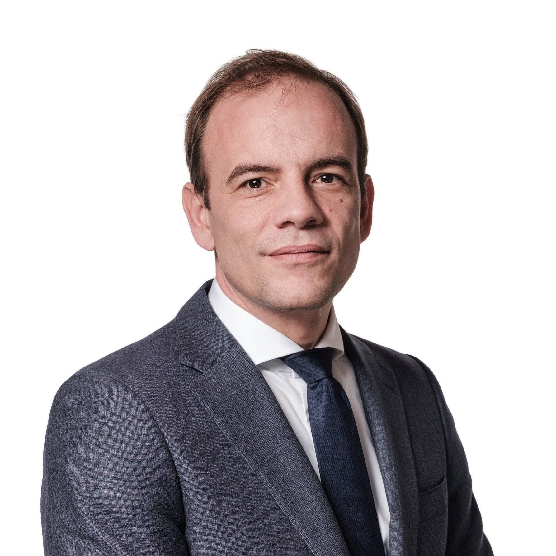 Man met bruine ogen, grijs jasje en donkere stropdas kijkt vriendelijk. 