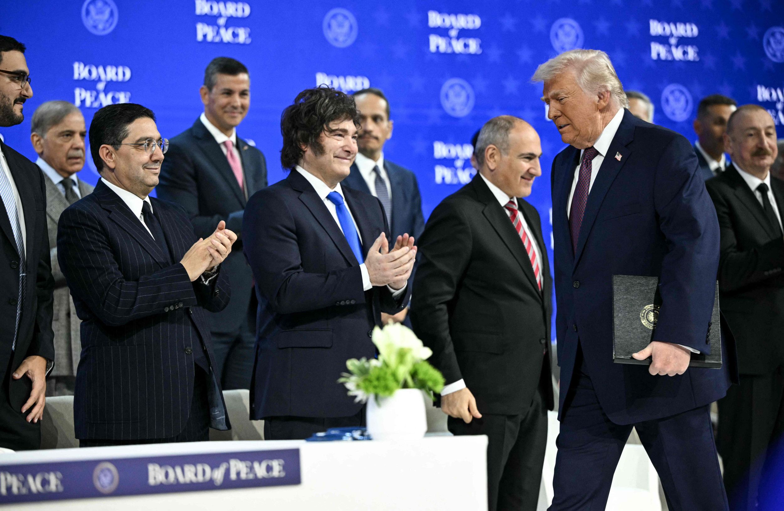 Mannen in pak lachen en klappen voor een man in pak. 