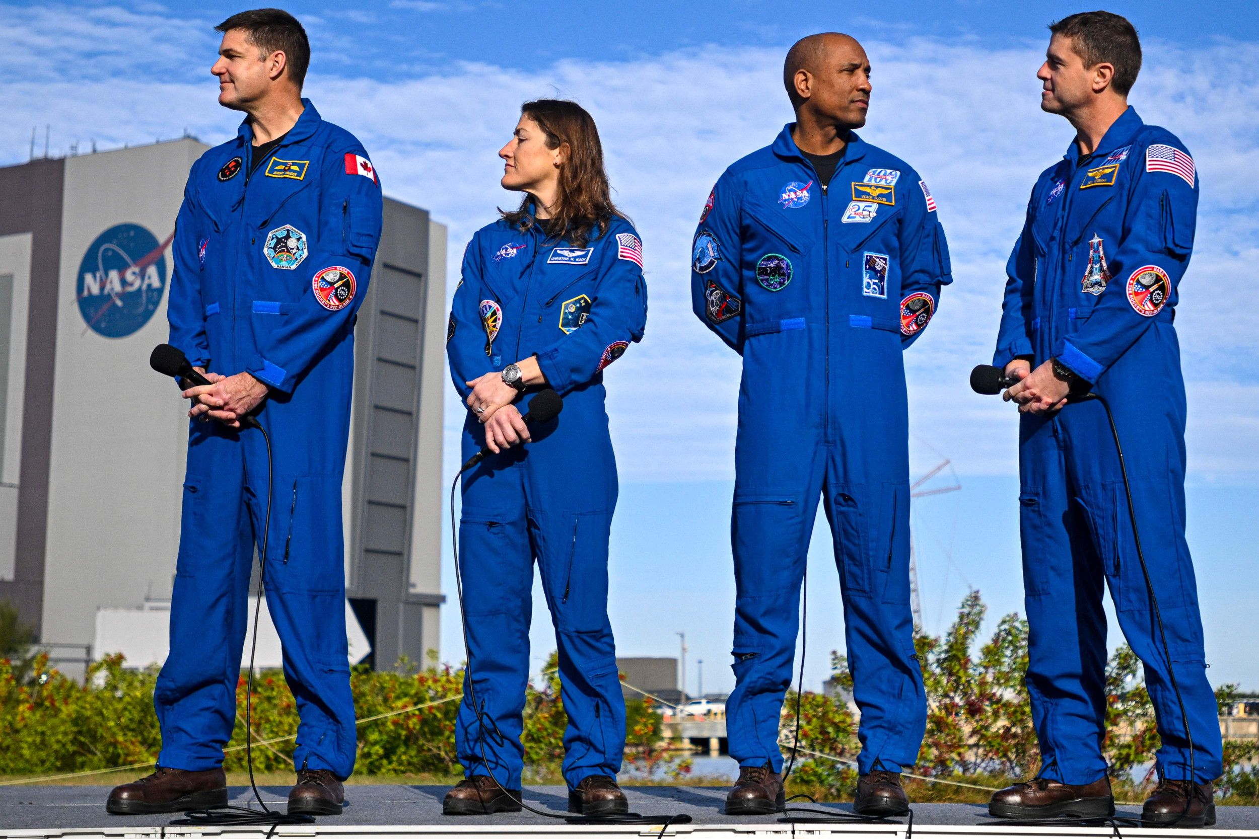 Vier astronauten in blauw uniform op een rij.
