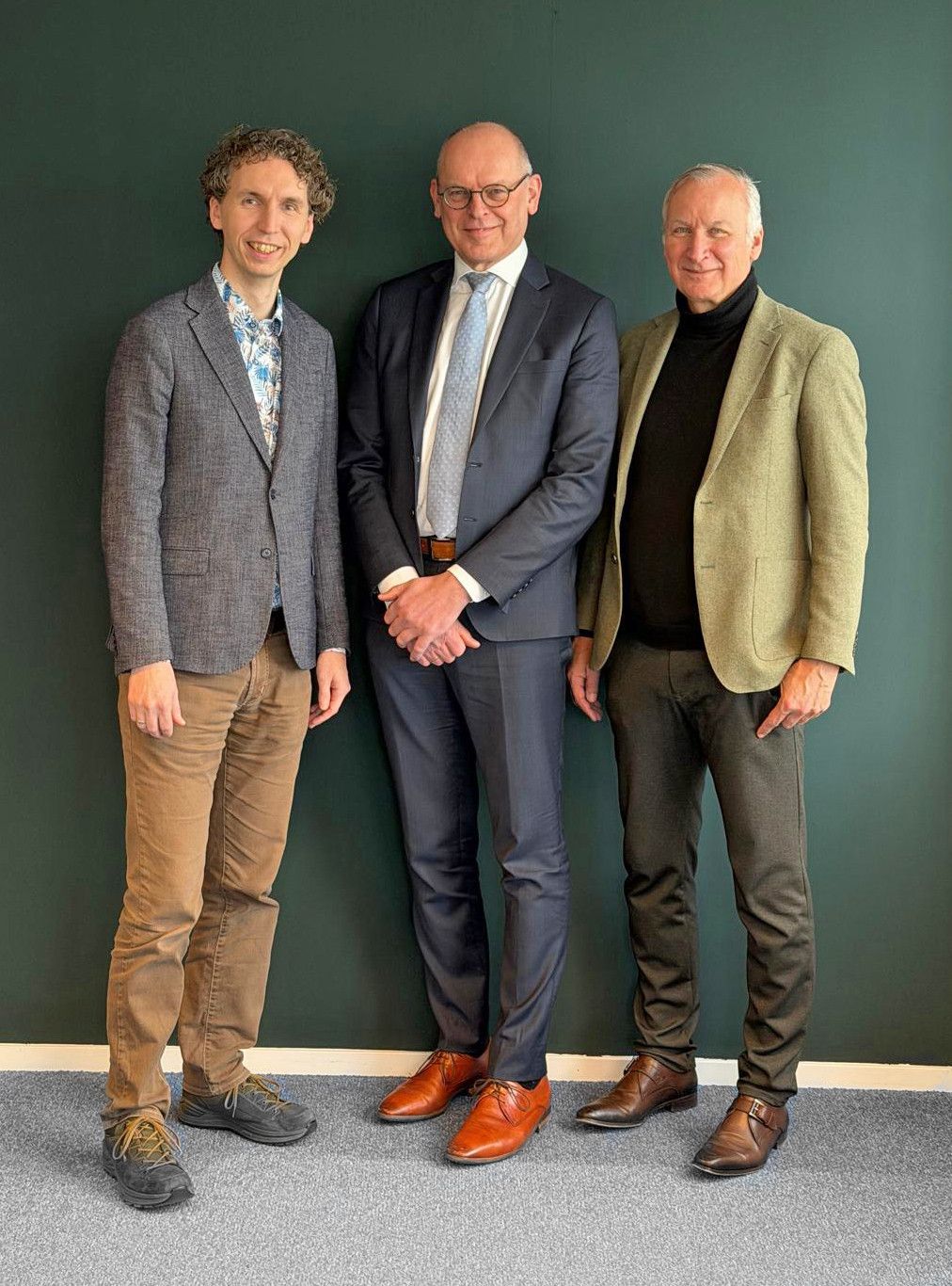 Willem Baarssen, Aart-Jan van der Wekken en Raymond Warnaar, drie mannen, staande voor een groene muur.