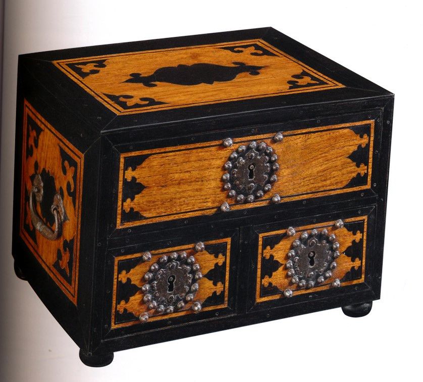 Foto van een zwartgeverfd houten kistje met grijs beslag. Het hout is op verschillende plekken nog te zien.