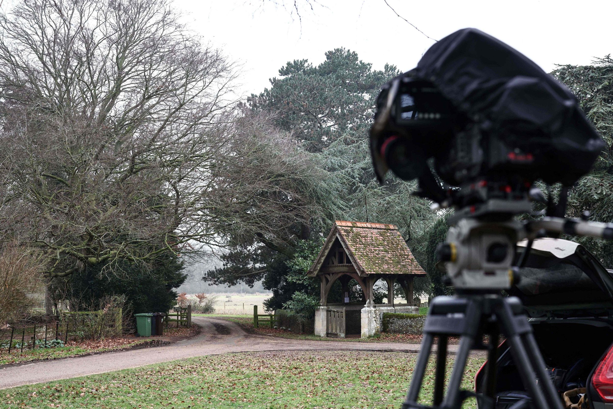 Een camera is op een weg gericht waarlangs bomen staan. Ook is er een toegangspoort.