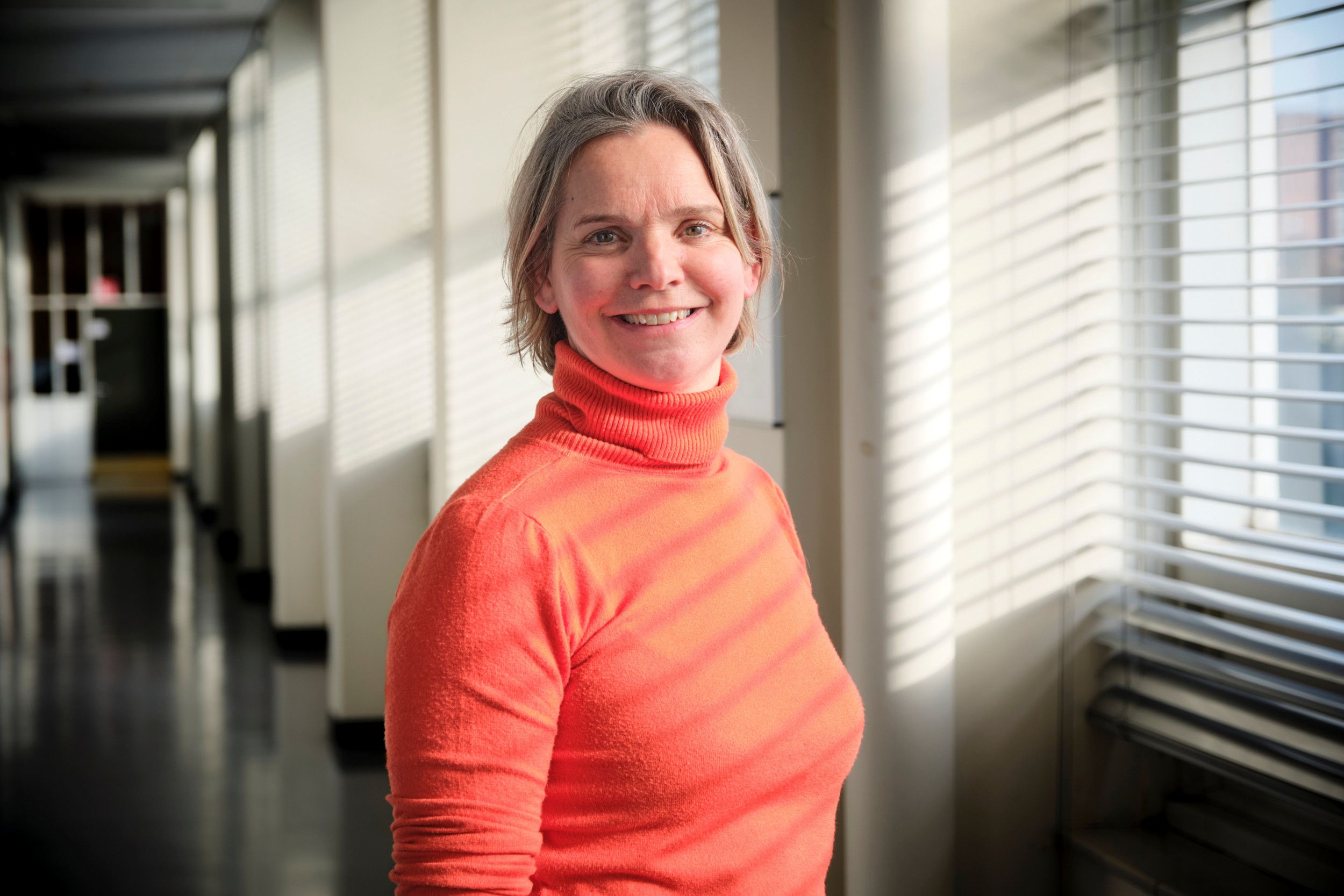 Portretfoto van een vrouw met kort blond haar en een coltrui.