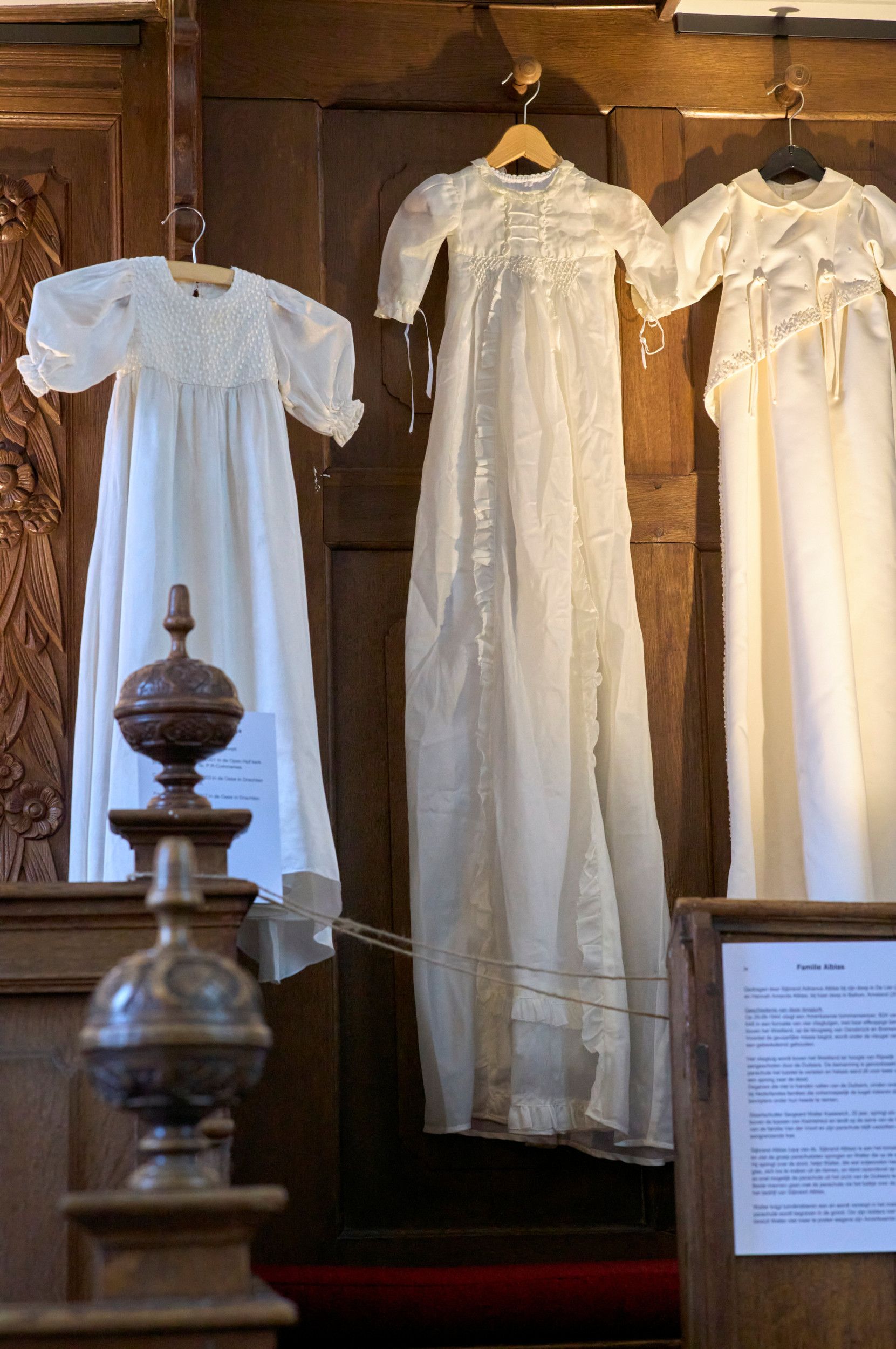 Een lange jurk, hangend aan een wand. 