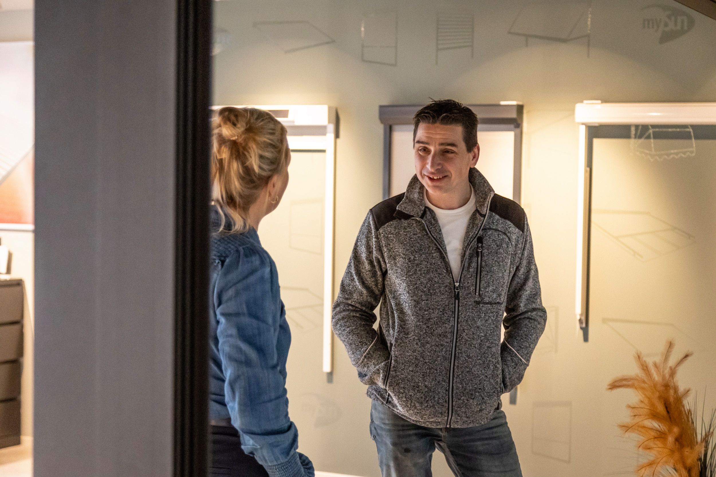 Twee mensen in een showroom met rolluiken