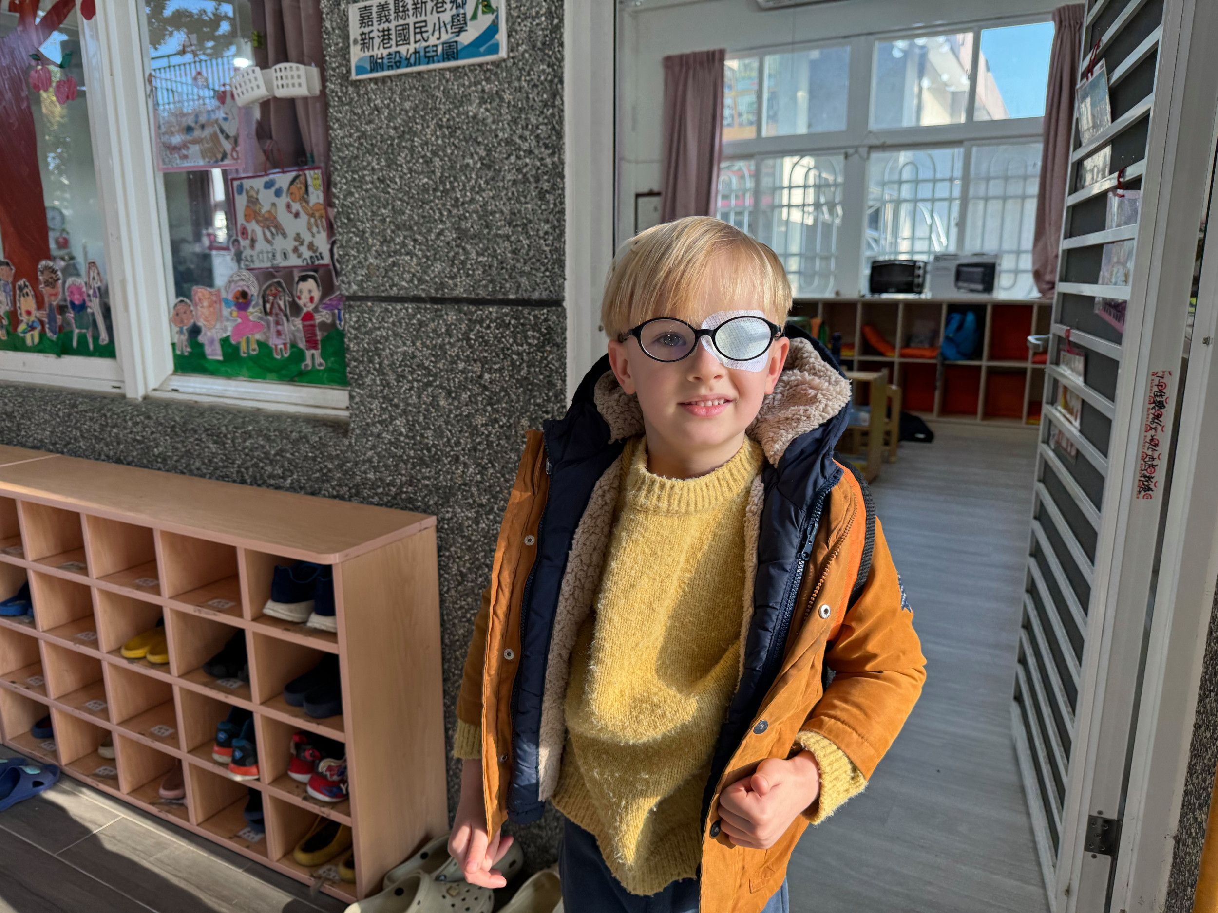 Kleuter naast schoenenrek.