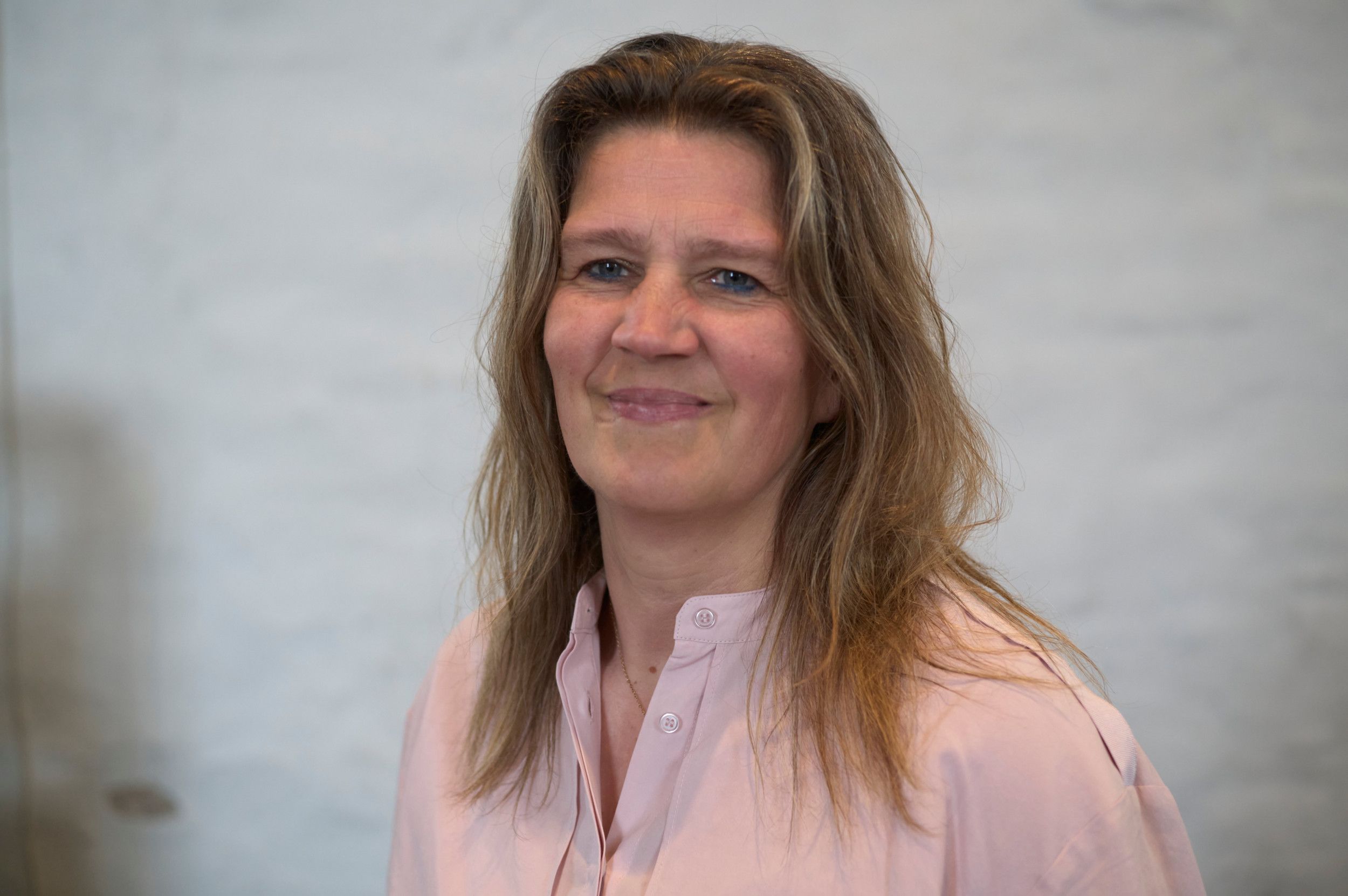 Een lachende vrouw, met het haar los op de schouders.