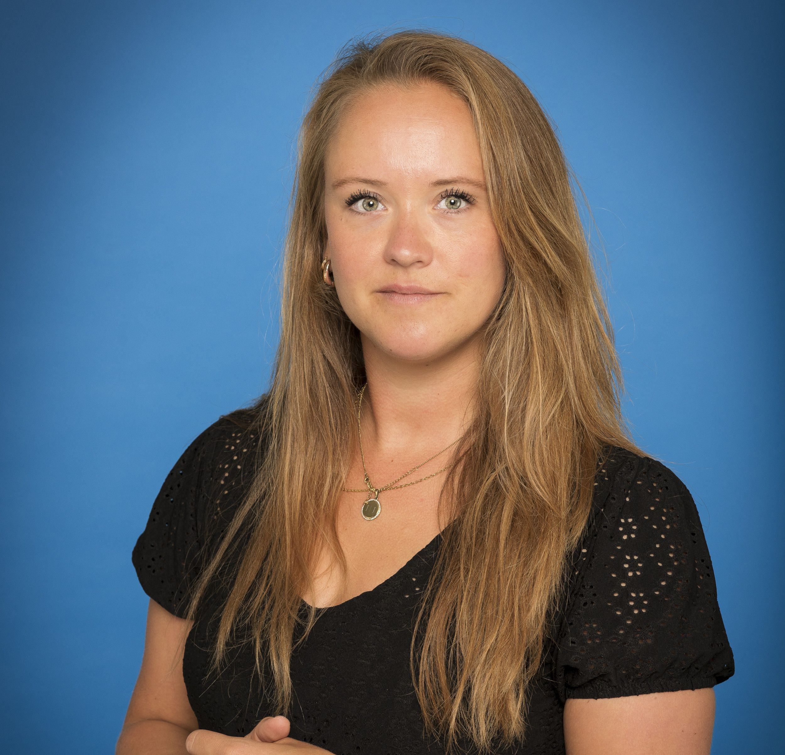 Jonge vrouw met lang lichtbruin haar en zwart truitje.