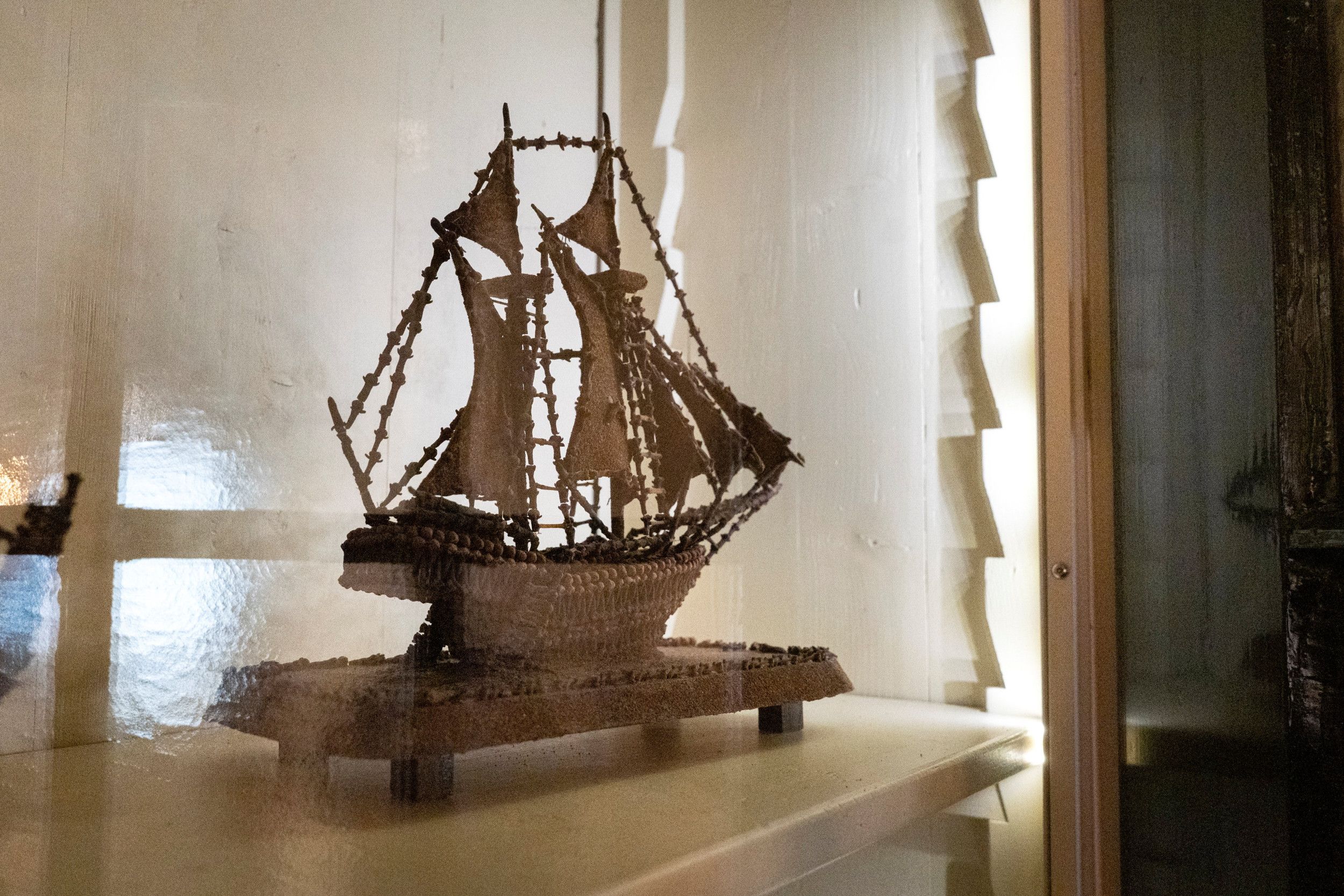 Scheepsmodel achter spiegelend glas.