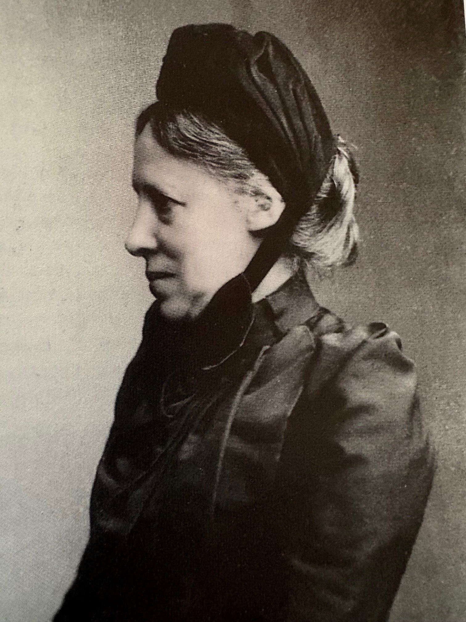 Zijaanzicht van een oudere vrouw met een zwart hoofddeksel.