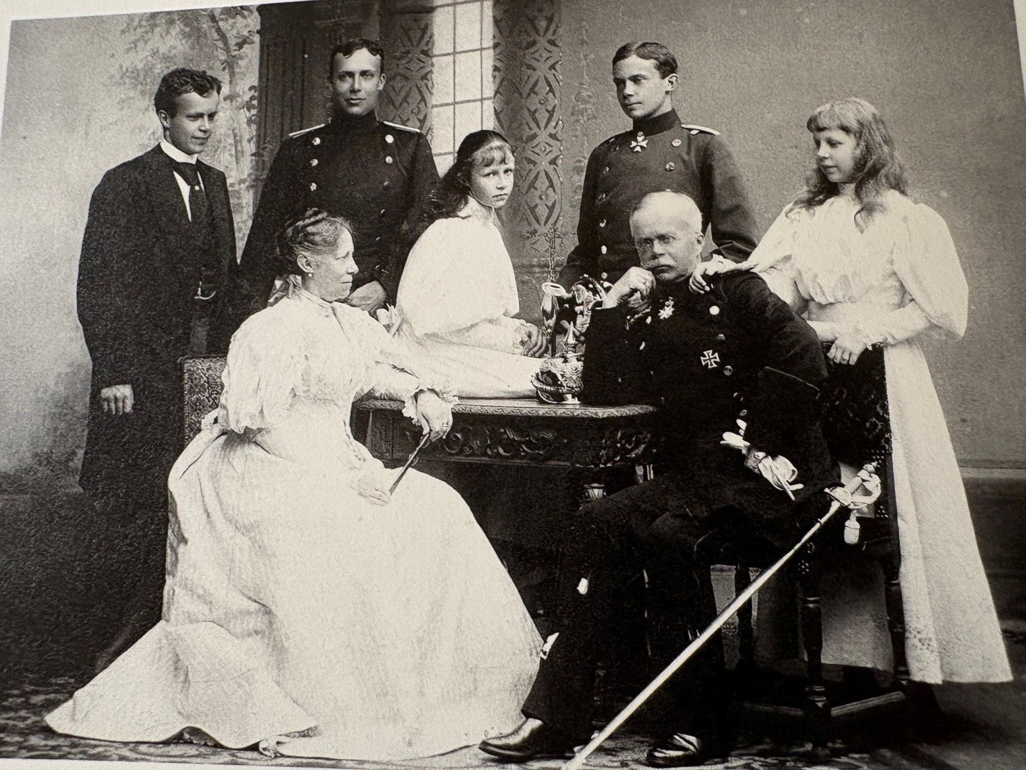 Een man in een uniform en zijn vrouw in een lichte jurk. Daarachter hun vijf kinderen.