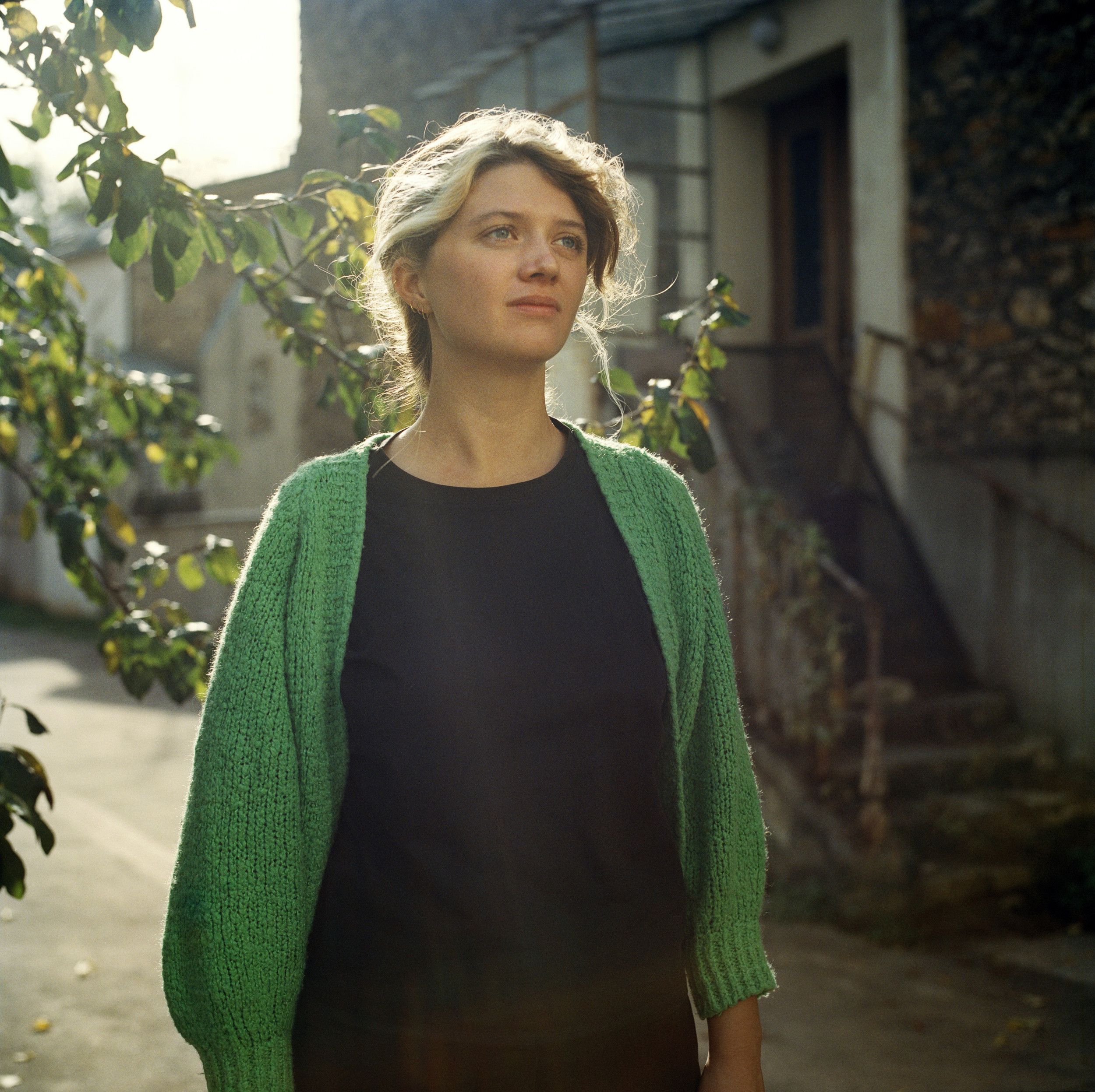 Foto van Emma Doude van Troostwijk, een jonge vrouw met blond haar, zwarte kleding met een groen vest erover.