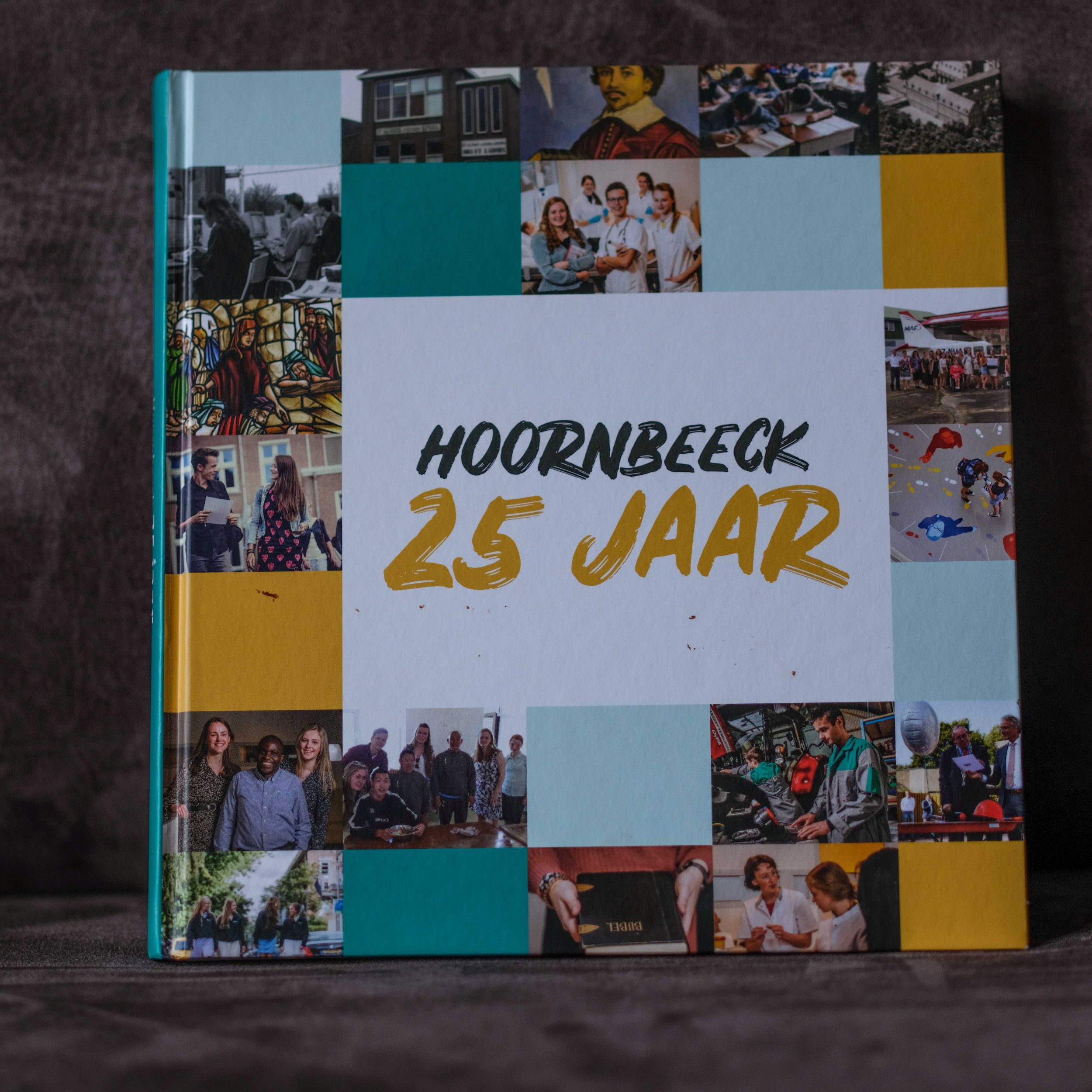 Foto van een jubileumboek van 25 jaar Hoornbeeck College. Op de voorkant staat een foto waar ook Milalu op staat.
