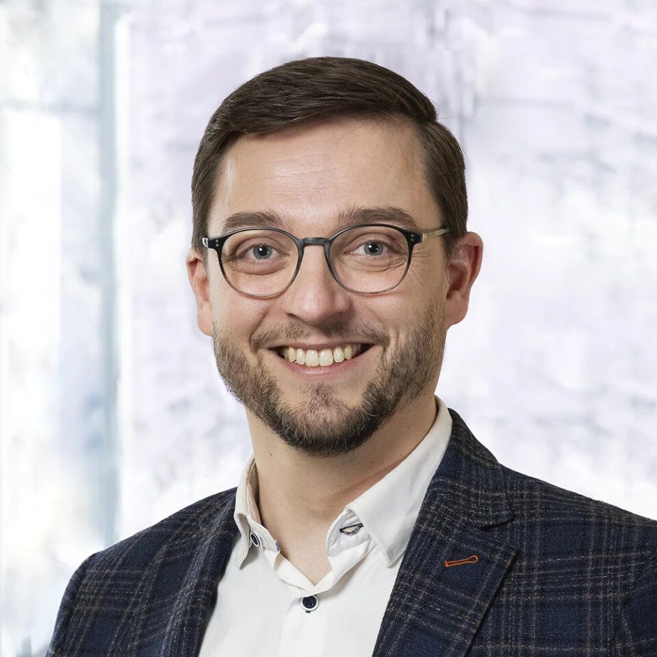 Portretfoto van een man met bruin haar en een bril.