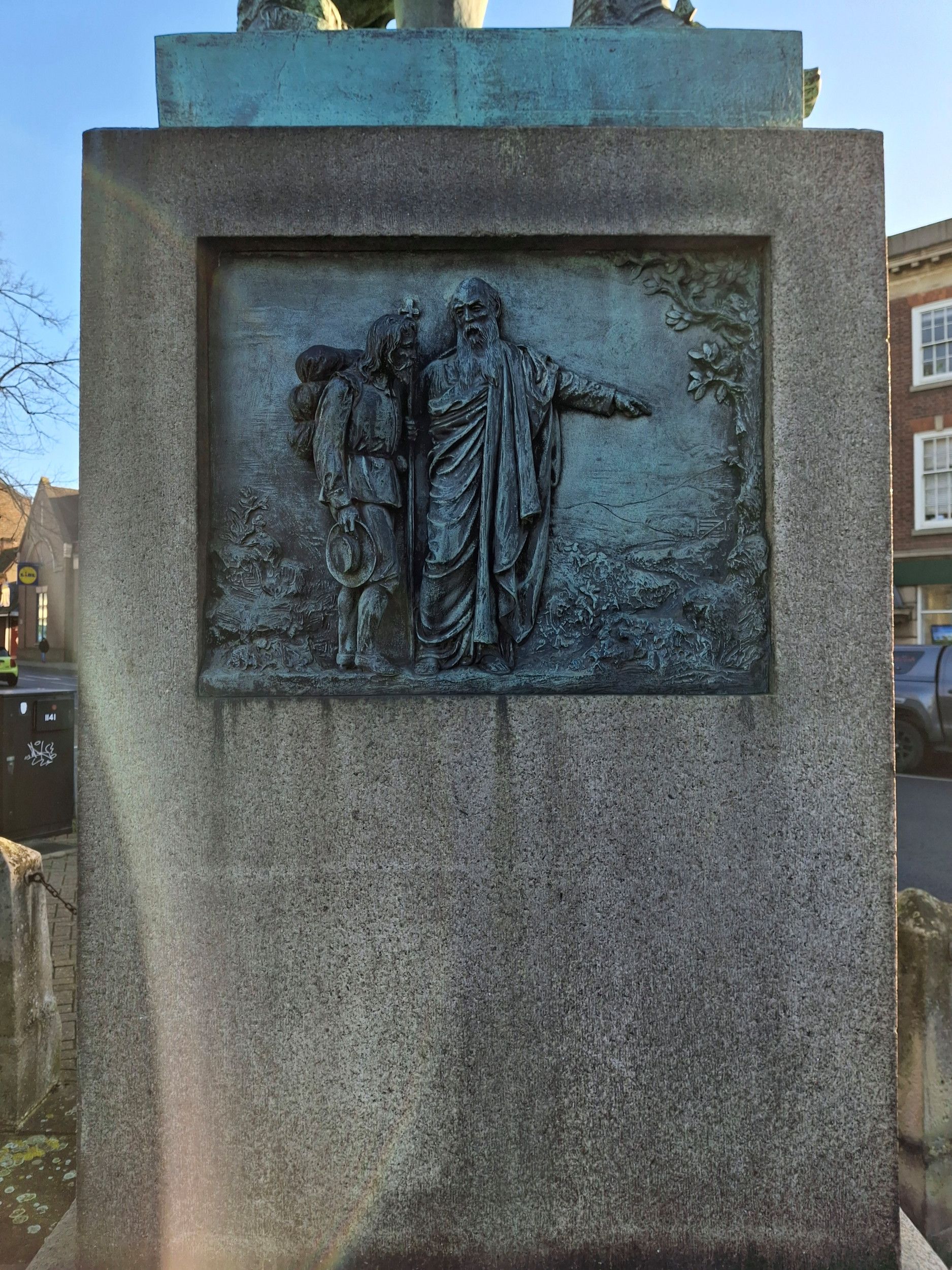 Illustratie van twee mannen op de stenen sokkel van het standbeeld.