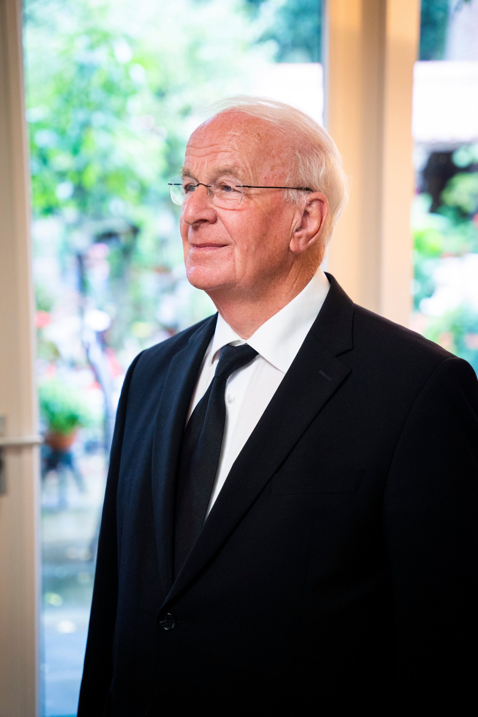 Glimlachende predikant in een zwart pak.