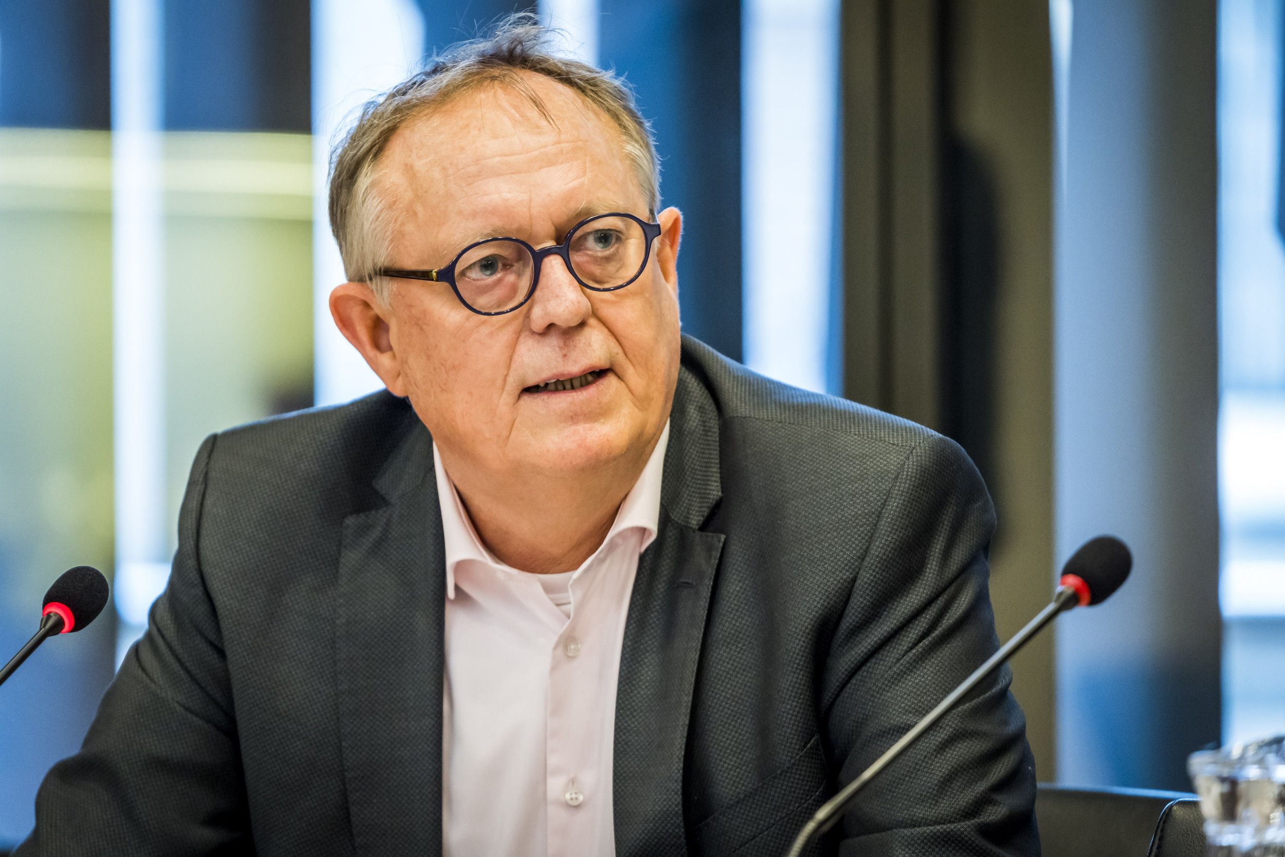 Man in pak met een bril. 