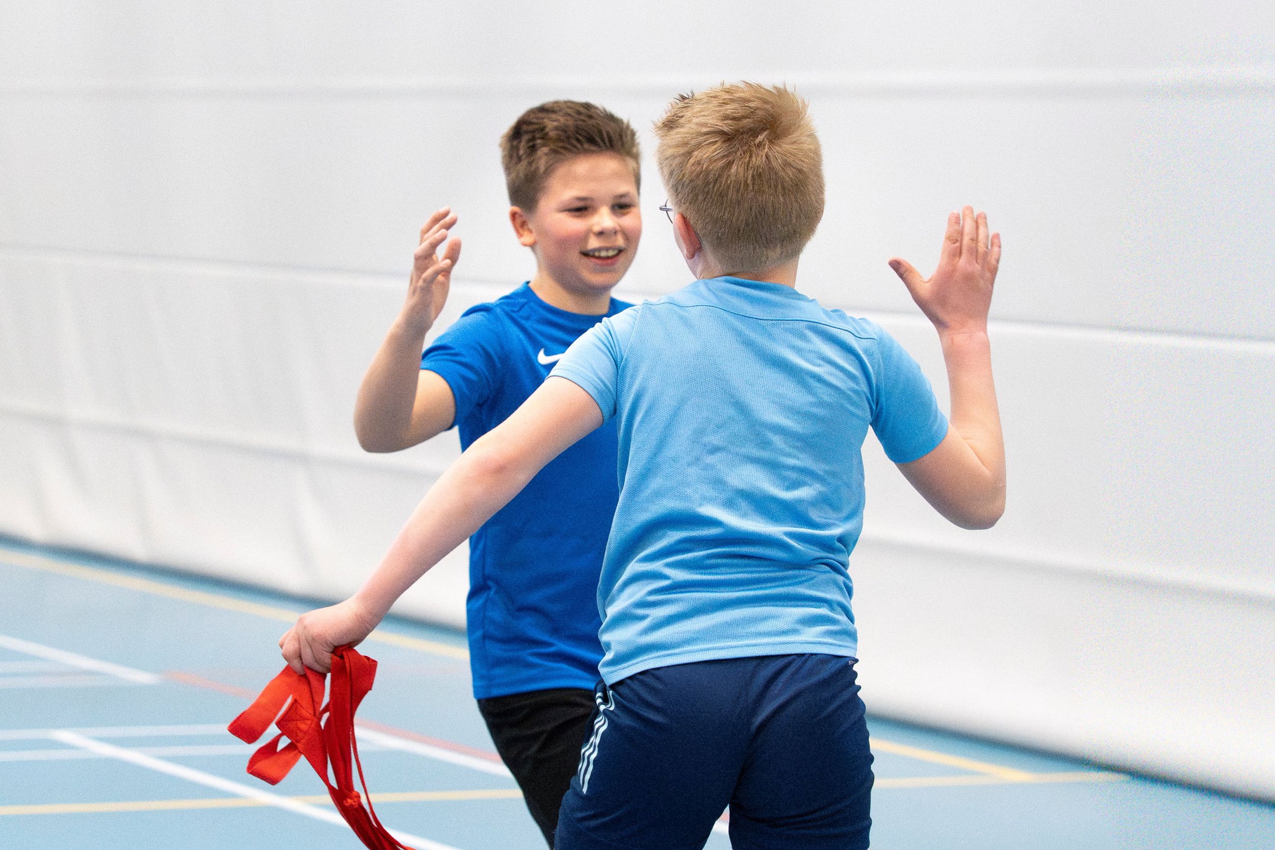 Twee jongens in blauwe shirtjes geven elkaar een high five