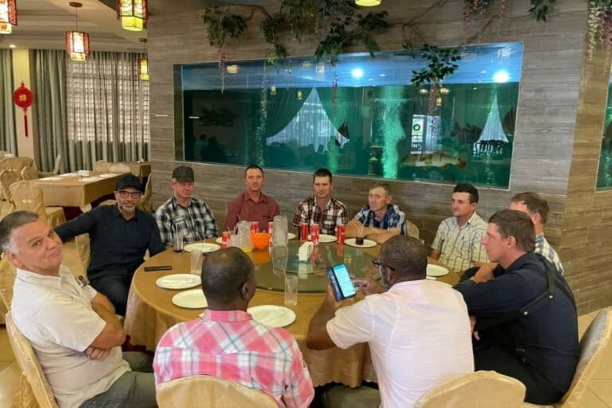 Een groep mennonitische jonge mannen rond een tafel.