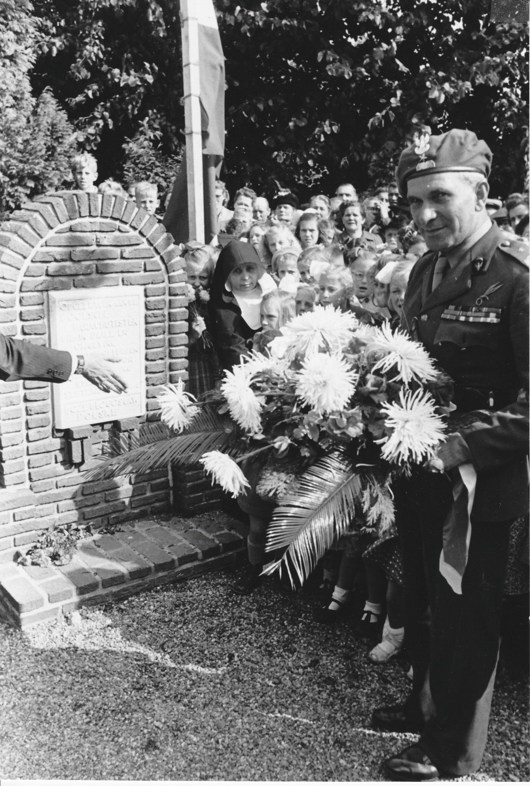 Zwart-witfoto van een man met een baret met een groot bloemstuk.