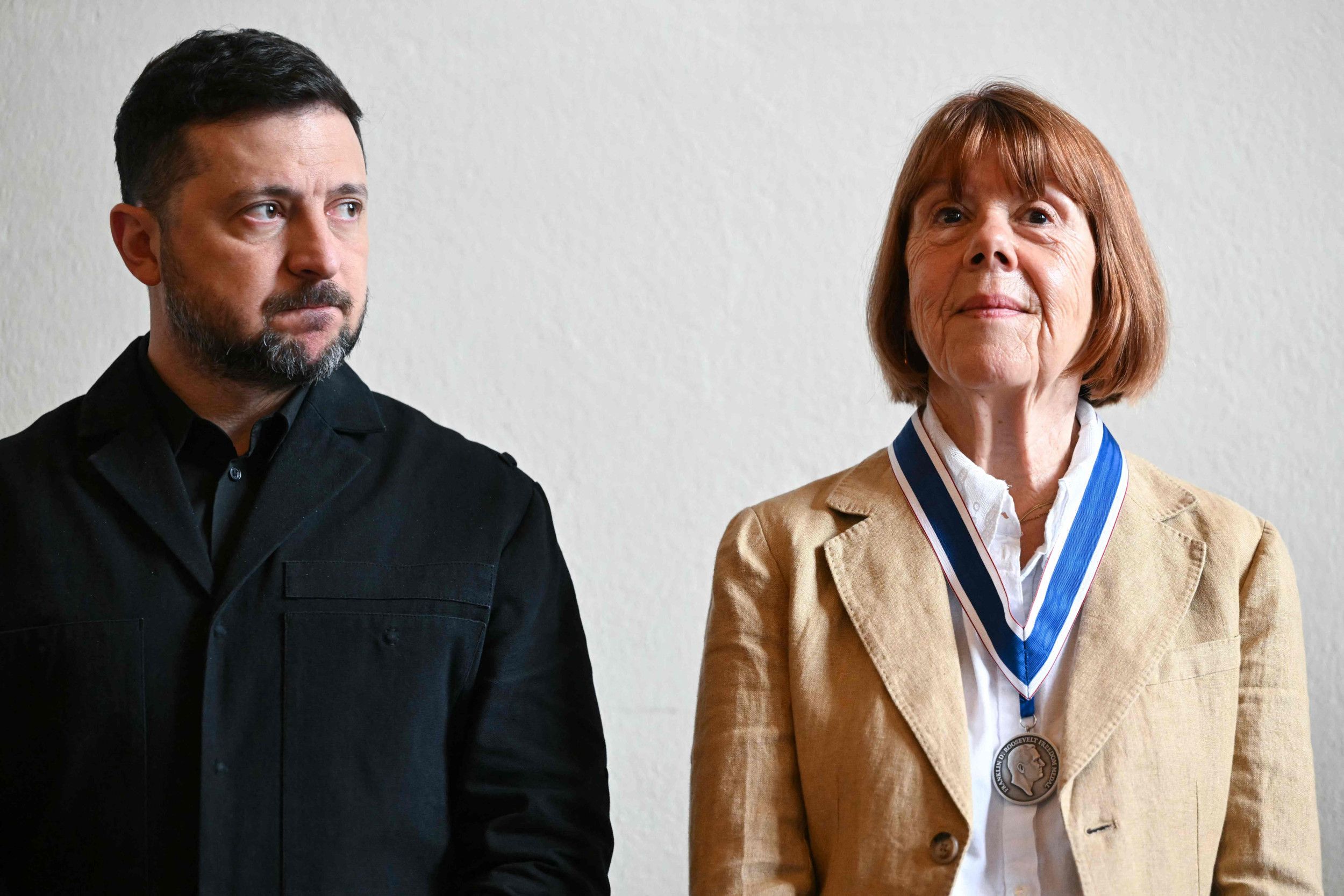 Een man in zwarte kleding naast een oudere vrouw met de Rooseveltmedaille om haar hals.