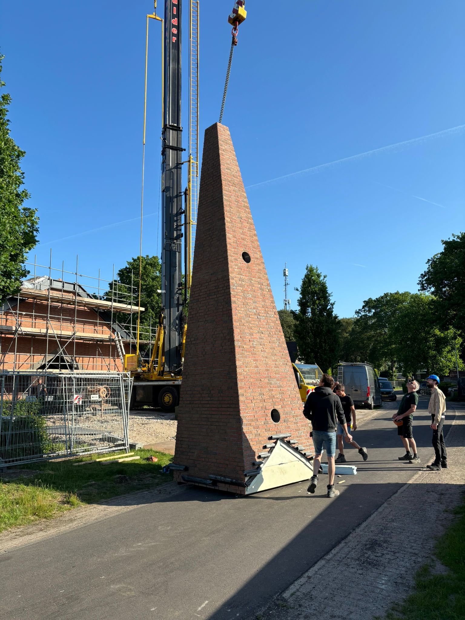 Het torentje wordt door een hoge kraan omhooggetakeld.