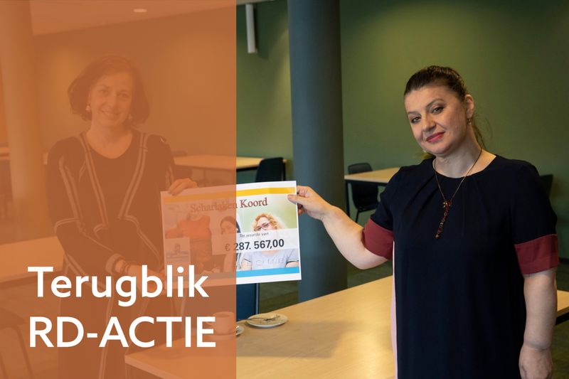 Twee vrouwen tonen een cheque met een groot bedrag.